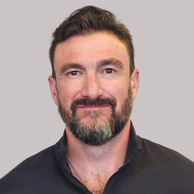 Man in a black shirt looking at the camera